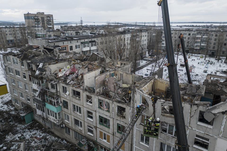 Rescue workers clear the rubble of the residential building which was destroyed by a Russian rocket in Pokrovsk, Ukraine, Wednesday, Feb. 15, 2023. According to local authorities, at least 2 people were killed and 12 injured. (AP Photo/Evgeniy Maloletka)
