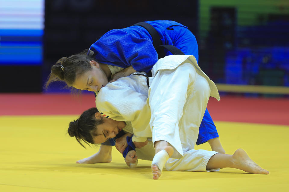 CORRECTS THAT SABINA GILIAZOVA IS ON TOP - Sabina Giliazova of Russia and Blandine Pont of France, bottom, in action during the women's -48 category at the World Judo Championships in Doha, Qatar, Sunday, April 5, 2023. (AP Photo/Hussein Sayed)