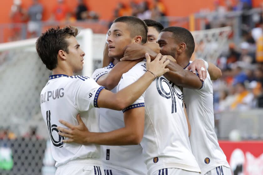 Los Angeles Galaxy forward Dejan Joveljic, center, is surrounded by teammates as they celebrate.