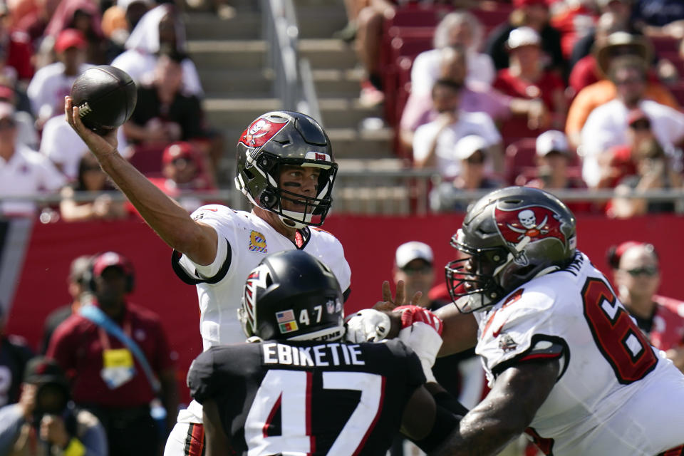 Tampa Bay Buccaneers quarterback Tom Brady (12) throws under pressure from Atlanta Falcons defensive end Arnold Ebiketie (47) during the second half of an NFL football game Sunday, Oct. 9, 2022, in Tampa, Fla. (AP Photo/Chris O'Meara)