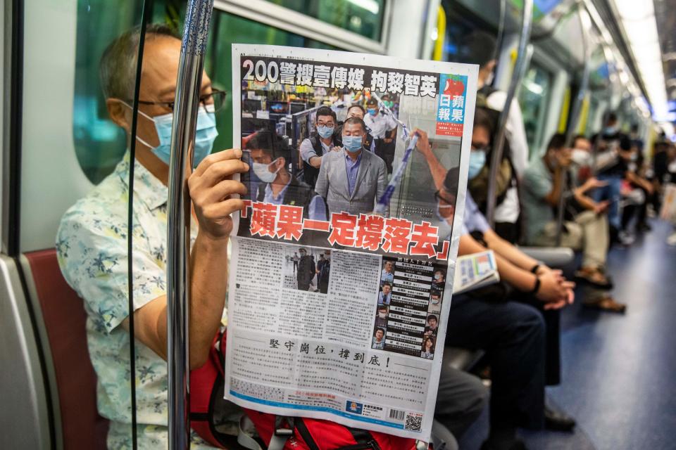 A commuter reads a copy of the Apple Daily newspaper on a train in Hong Kong on August 11, 2020, a day after authorities conducted a search of the newspaper's headquarters after the companys founder Jimmy Lai was arrested under the new national security law. - Hong Kong pro-democracy media tycoon Jimmy Lai was arrested on August 10 and led in handcuffs through his newspaper office as police raided the building, part of a sweeping crackdown on dissent since China imposed a security law on the city. (Photo by ISAAC LAWRENCE / AFP) (Photo by ISAAC LAWRENCE/AFP via Getty Images)