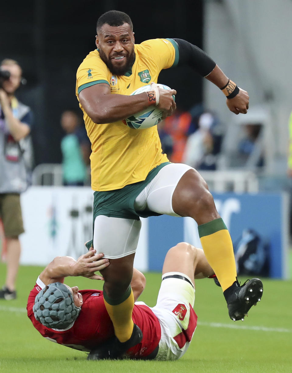 Australia's Samu Kerevi runs past Wales Jonathan Davies during the Rugby World Cup Pool D game at Tokyo Stadium between Australia and Wales in Tokyo, Japan, Sunday, Sept. 29, 2019. (AP Photo/Eugene Hoshiko)