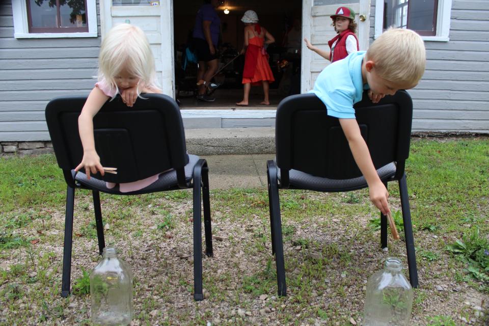 Outside of the Exeter Township Historical Museum, Eleanor Winterholler, 3, (left) and her brother, Toby, 4, drop clothes pins into glass bottles.