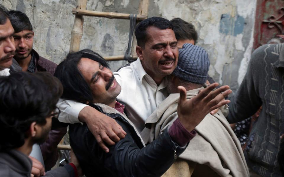 Relatives of a family who were killed by counter-terrorism officers mourn as bodies arrive to their home - AP