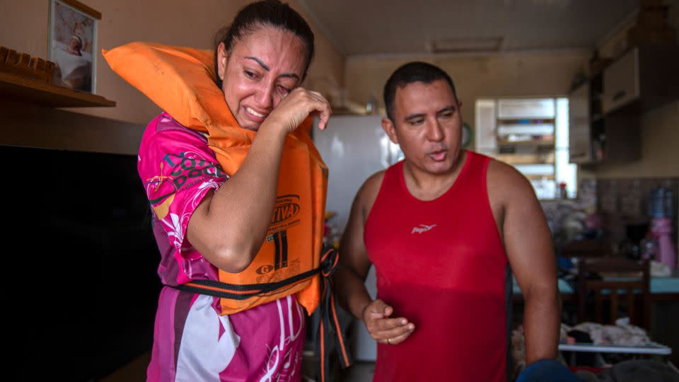 Katiane Mello, left, and her husband, James Vargas, before leaving their flooded home in Eldorado do Sul, in the state of Rio Grande do Sul, on May 9, 2024. - Carlos Fabal/AFP/Getty Images