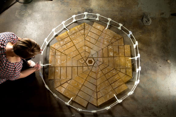 Shannon Zirbel, a graduate student at Brigham Young University who helped work on the project, unfolds one of the solar panel arrays.