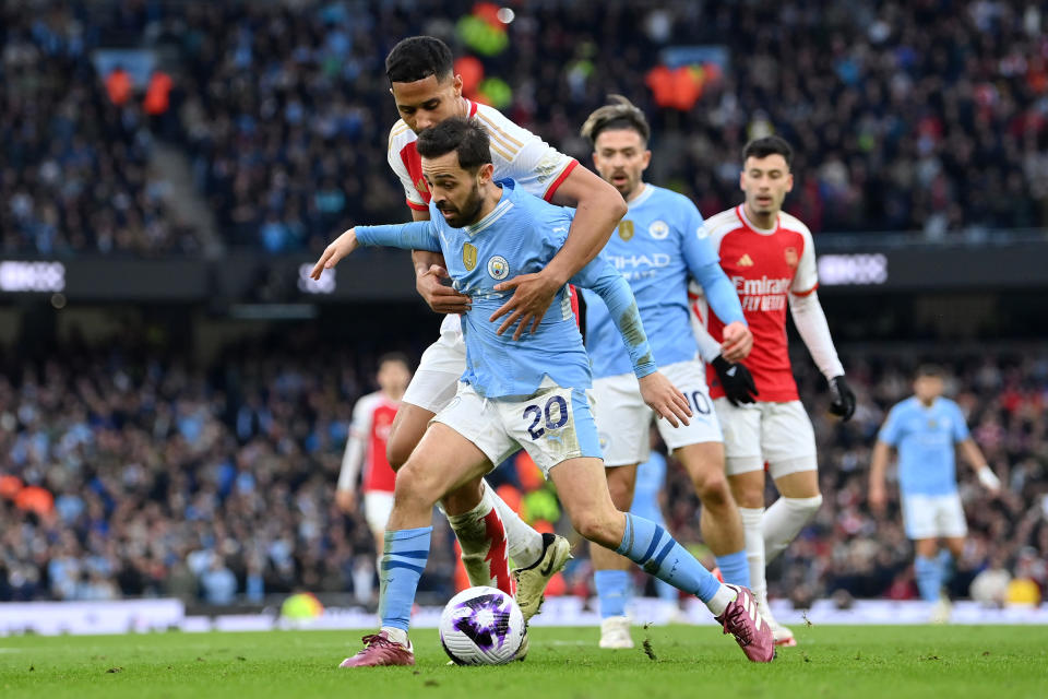 MANCHESTER, ENGLAND - MARCH 31: Bernardo Silva of Manchester City holds off William Saliba of Arsenal during the Premier League match between Manchester City and Arsenal FC at Etihad Stadium on March 31, 2024 in Manchester, England. (Photo by Justin Setterfield/Getty Images) (Photo by Justin Setterfield/Getty Images)