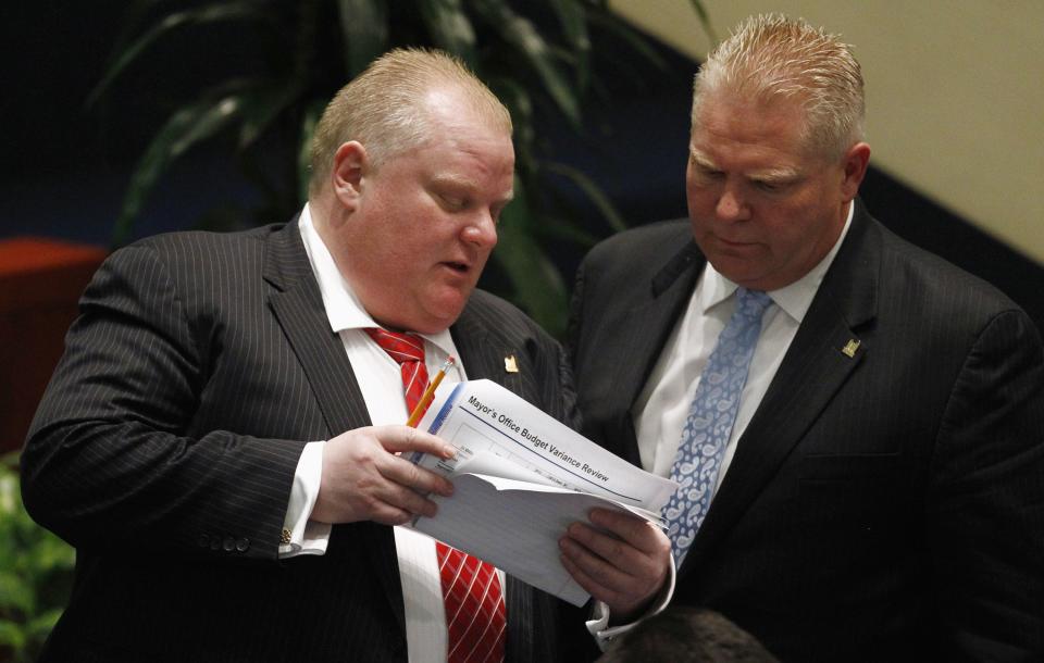 Toronto Mayor Rob Ford (L) and and city councillor Doug Ford attend a special council meeting at City Hall in Toronto November 18, 2013. The Toronto city council may further curb the powers of embattled Mayor Rob Ford on Monday, slashing his office budget and offering his staff a chance to transfer to new jobs. REUTERS/Aaron Harris (CANADA - Tags: POLITICS TPX IMAGES OF THE DAY)