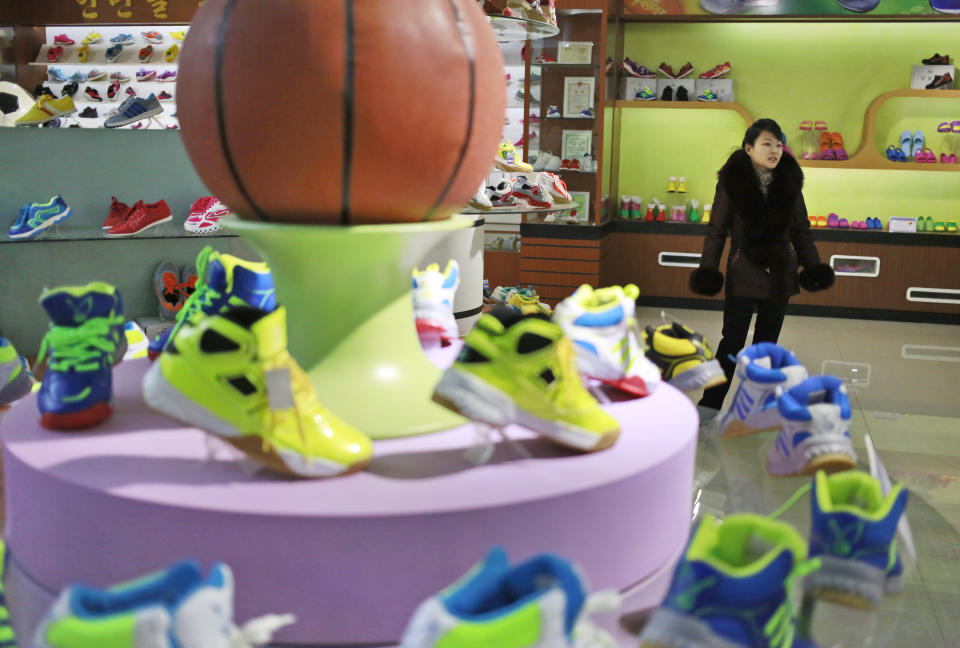 In this Friday, Feb. 1, 2019, photo, a guide stands near a basketball shoe display in a product exhibition room at the Ryuwon Shoe Factory that specializes in sports footwear, in Pyongyang, North Korea. North Korean pop culture, long dismissed by critics as a kitschy throwback to the dark days of Stalinism, is getting a major upgrade under leader Kim Jong Un. The changes are being seen in everything from television dramas and animation programs to the variety and packaging of consumer goods, which have improved significantly under Kim. (AP Photo/Dita Alangkara)