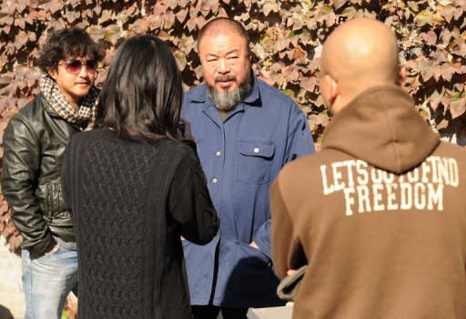 Chinese artist Ai Weiwei (C) talks to unidentified friends in the his courtyard home and studio in Beijing on November 9, 2011. Thousands of people have donated funds to help Ai pay a huge tax fine, with some throwing money wrapped in paper planes into his garden, the Chinese artist said