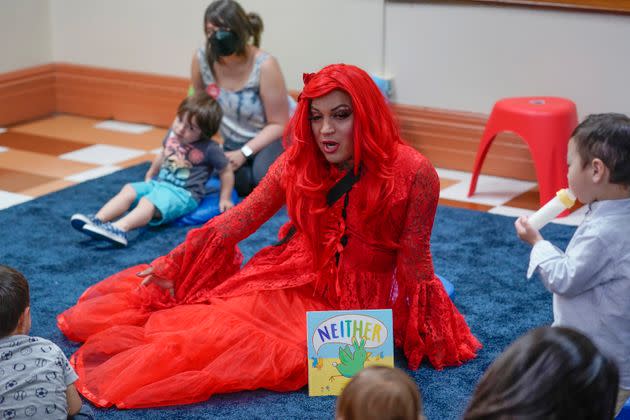 A drag queen who goes by the name Flame reads stories to children and their caretakers during a Drag Time Story Hour last summer at a New York public library.