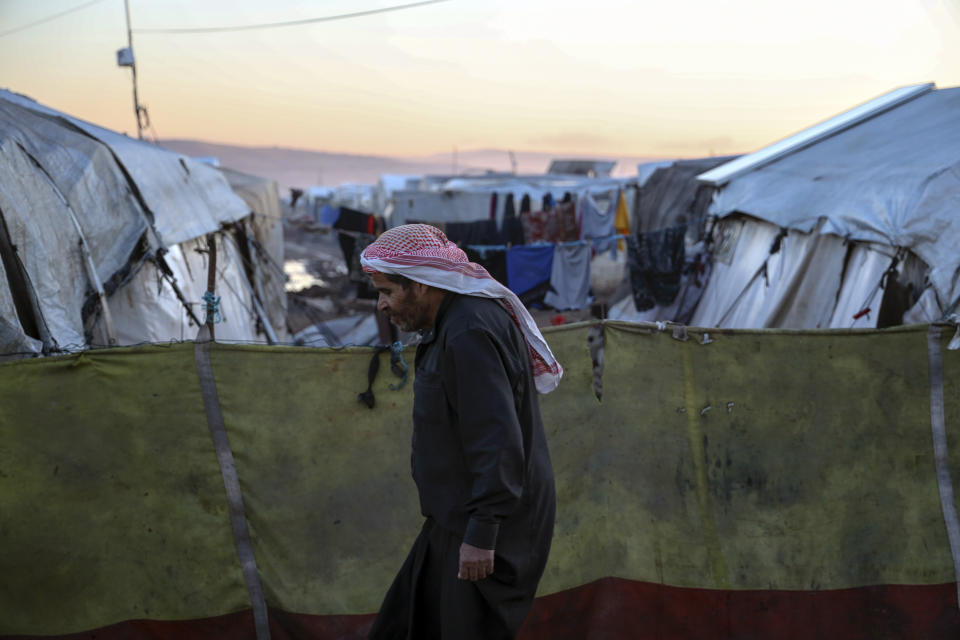 A man walks next to tents used as shelters for the people have lost their homes in the February 2023 earthquake, in Idlib province, Syria, Saturday, Jan. 27, 2024. A year after the devastating 7.8 magnitude earthquake struck southern Turkey and northwestern Syria, a massive rebuilding effort is still trudging along. The quake caused widespread destruction and the loss of over 59,000 lives. (AP Photo/Omar Albam)