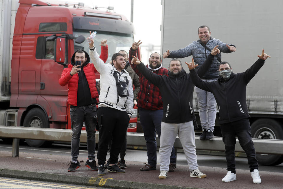 European truck drivers pose for a photograph as they wait for the port to reopen in Dover, the main ferry link between southern England and France, Tuesday, Dec. 22, 2020. Trucks waiting to get out of Britain backed up for miles and people are left stranded at airports as dozens of countries around the world slapped tough travel restrictions on the U.K. because of a new and seemingly more contagious strain of the coronavirus in England.(AP Photo/Kirsty Wigglesworth)