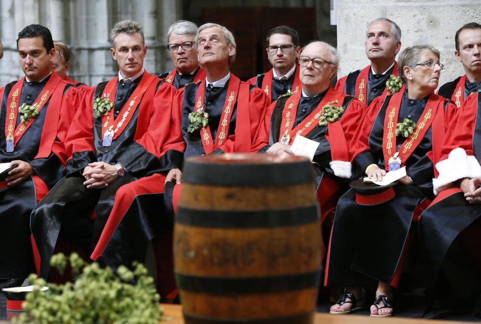 Members of the Knighthood of the Brewers' Mash staff attend a mass in front of a barrel of beer at the Sint-Gudule Cathedral in Brussels