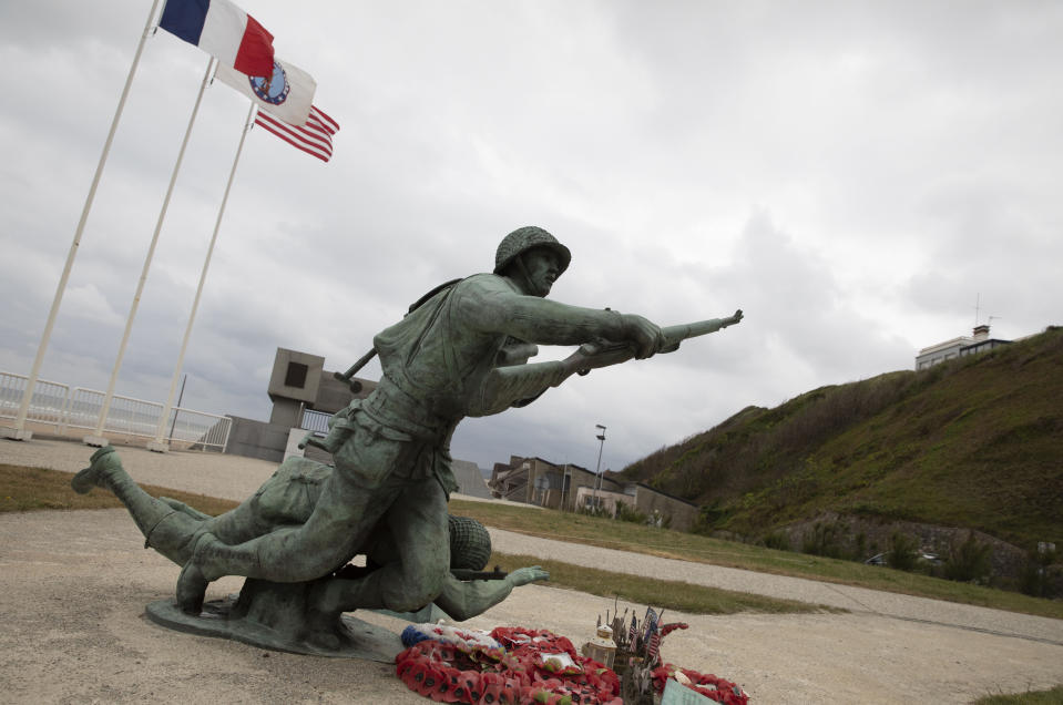 In this photo taken on Thursday, June 4, 2020, wreaths and flags sit in front of the Ever Forward memorial near Omaha Beach, in Vierville-sur-Mer, Normandy, France. In sharp contrast to the 75th anniversary of D-Day, this year's 76th will be one of the loneliest remembrances ever, as the coronavirus pandemic is keeping nearly everyone from traveling. (AP Photo/Virginia Mayo)