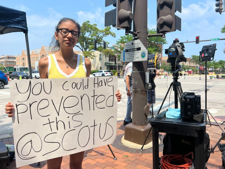 Stephanie Diaz holds a sign that says "You could have prevented this @SCOTUS."