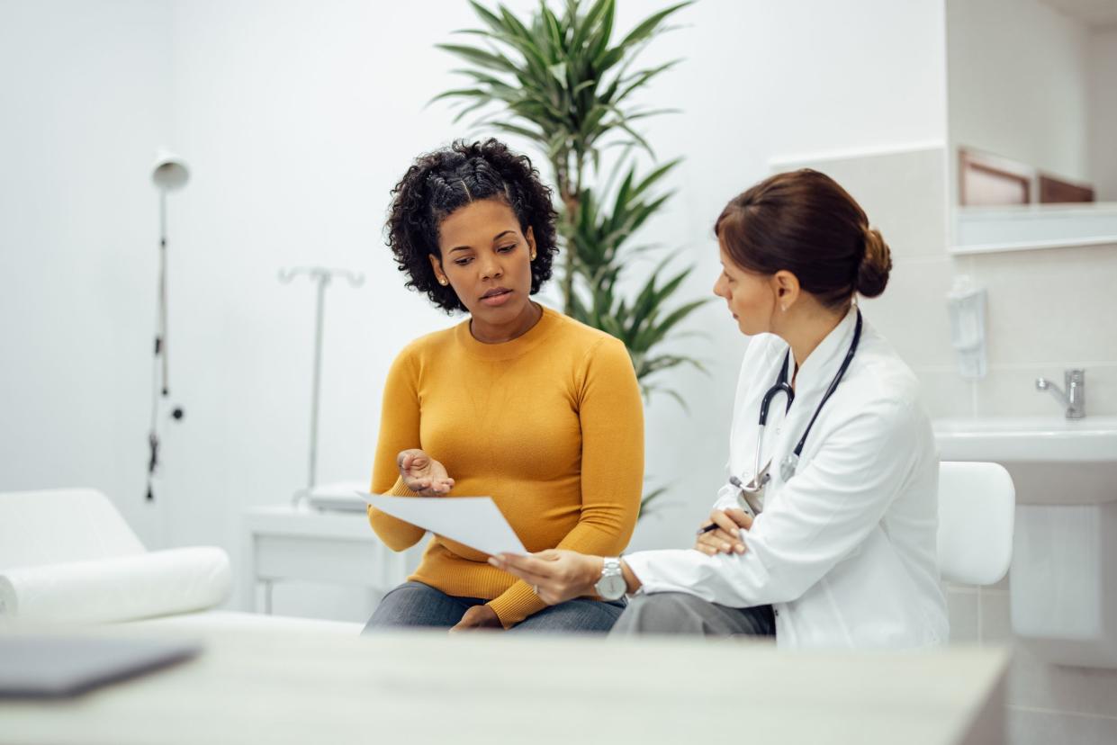 Female patient and doctor discussing test results in medical office.