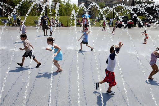 Excited children run though water as the fountains are turned on at Georgetown Waterfront Park in Washington, on Wednesday, June 20, 2012. Temperatures across the Northeast are expected to approach triple digits. (AP Photo/Jacquelyn Martin)