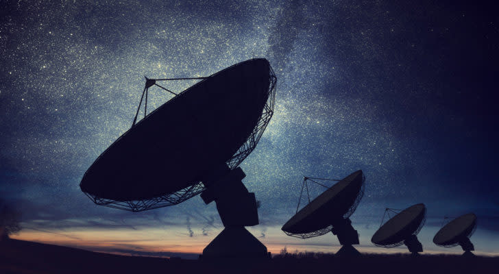 space SPACs Silhouettes of satellite dishes or radio antennas against night sky