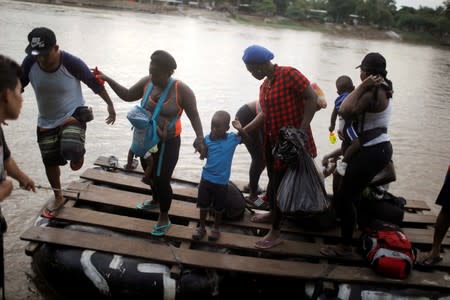 Haitian migrants get off a raft after crossing the Suchiate river from Tecun Uman, in Guatemala, to Ciudad Hidalgo, as seen from Ciudad Hidalgo