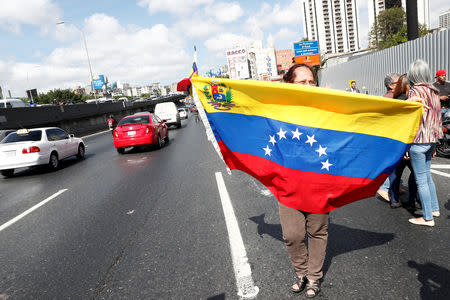 People wait for Juan Guaido, who many nations have recognised as the country's rightful interim ruler, to pass by on the motorway, in Caracas, Venezuela February 21, 2019. REUTERS/Carlos Jasso