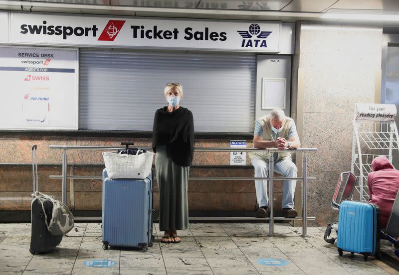 FILE PHOTO: Passengers wait for confirmation of flights outside the Swissport Ticket Sales counter as several airlines stopped flying out of South Africa, amidst the spread of the new SARS-CoV-2 variant Omicron, at O.R. Tambo International Airport, in Joha