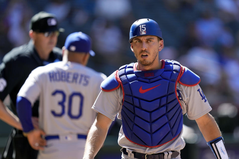 Los Angeles Dodgers catcher Austin Barnes, right, walks off the field after being ejected for arguing ball and strikes as Dodgers manager Dave Roberts (30) talks with umpire Lance Barrett, left, during the fifth inning of a baseball game against the Arizona Diamondbacks Sunday, April 9, 2023, in Phoenix. (AP Photo/Ross D. Franklin)