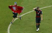 A fan runs on the pitch past Germany's Toni Kroos during their 2014 World Cup Group G soccer match at the Pernambuco arena in Recife June 26, 2014. REUTERS/Ruben Sprich (BRAZIL - Tags: SOCCER SPORT WORLD CUP TPX IMAGES OF THE DAY)