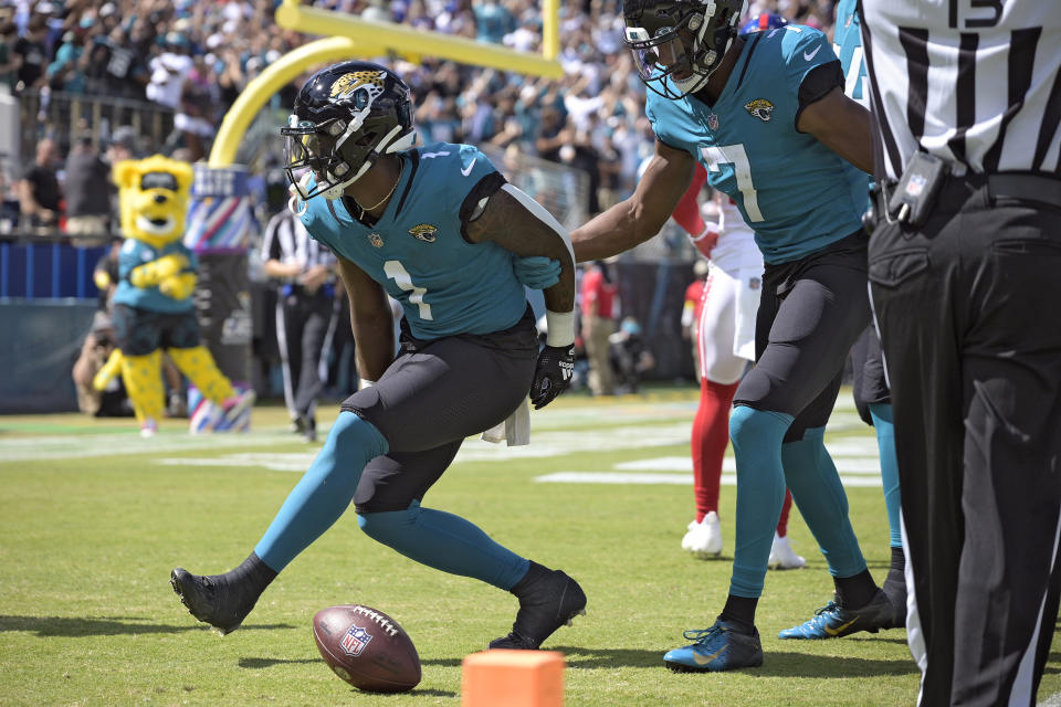 Jacksonville Jaguars running back Travis Etienne Jr. (1) celebrates his touchdown run against the New York Giants with wide receiver Zay Jones (7) during the first half of an NFL football game Sunday, Oct. 23, 2022, in Jacksonville, Fla. (AP Photo/Phelan M. Ebenhack)