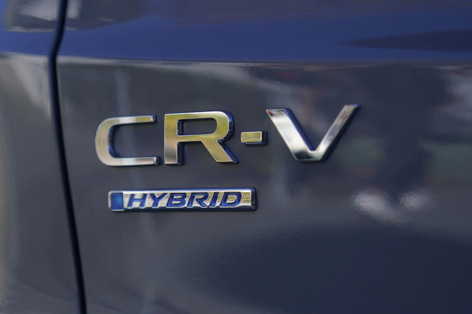 Logos are shown on the exterior of a 2024 Honda CR-V Hybrid in Sunnyvale, Calif., Monday, Dec. 11, 2023. Like many hybrid buyers, Shilander Singh, an Uber driver, said that for him, the gas savings helped tip the price equation in favor of a Honda CR-V hybrid over the corresponding gasoline model.(AP Photo/Jeff Chiu)