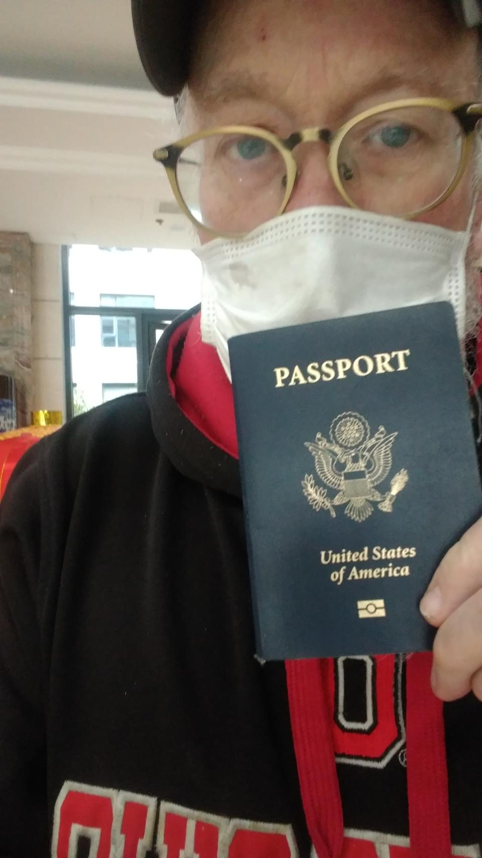 John McGory holds passport from the Wuhan Police, Feb 1, 2020.