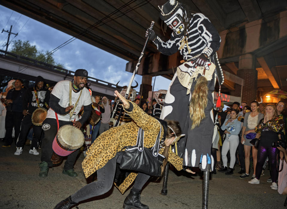 The North Side Skull & Bones Gang invites people to dance with them as they rise before dawn, costumed as skeletons, on Mardi Gras Day in New Orleans, La. Tuesday, Feb. 25, 2020. The gang marches though the Treme neighborhood waking people up with song, dance. (Max Becherer/The Advocate via AP)