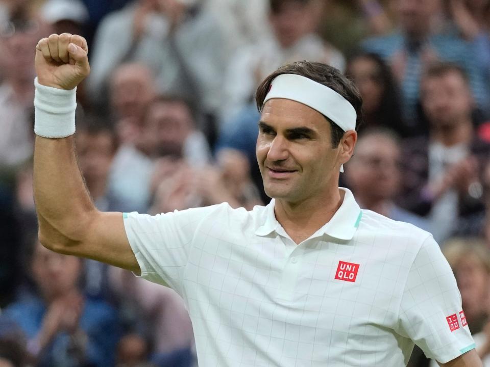 Roger Federer holds up his fist and smiles during Wimbledon in 2021.