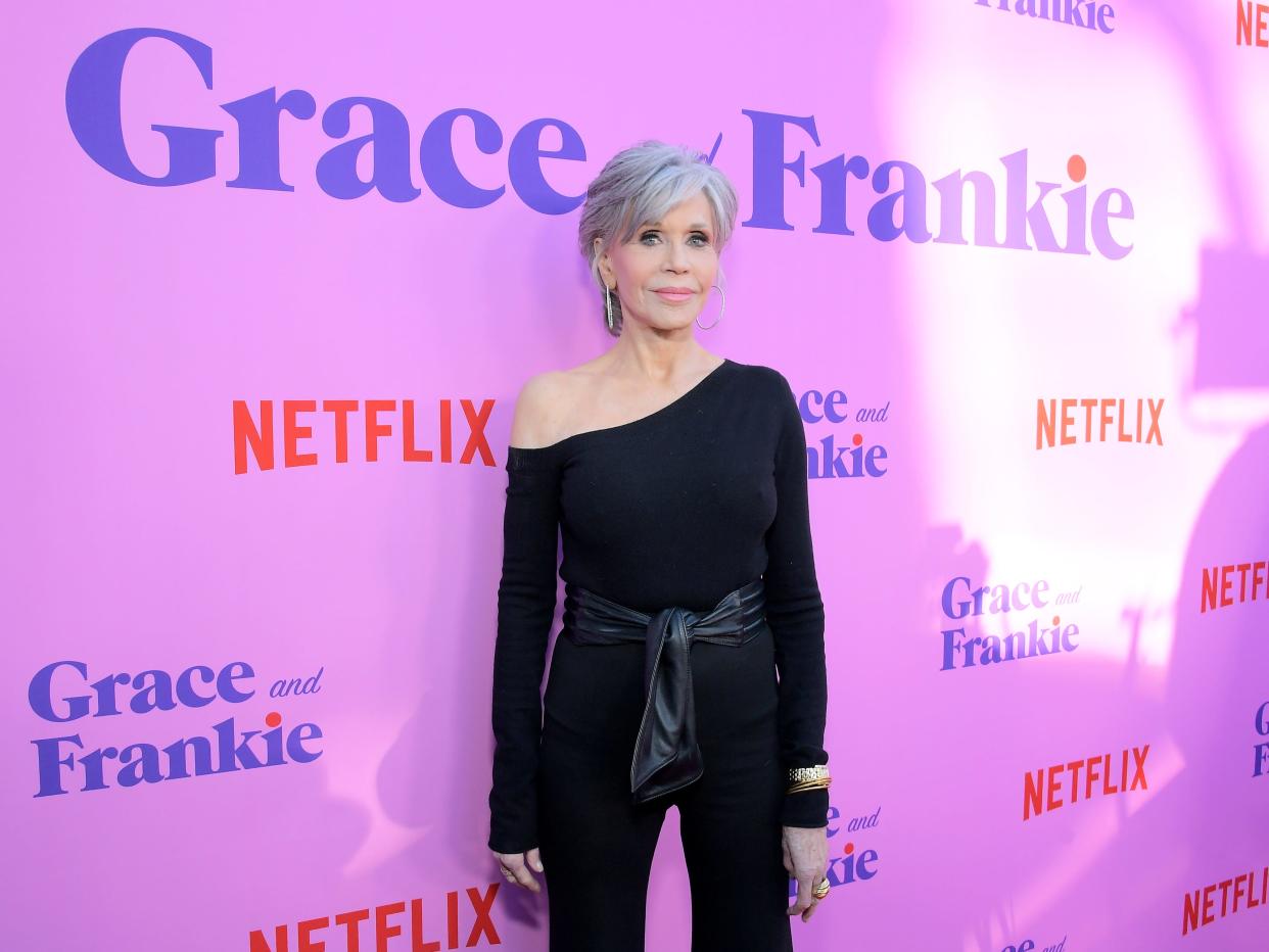 Jane Fonda stands on a red carpet.