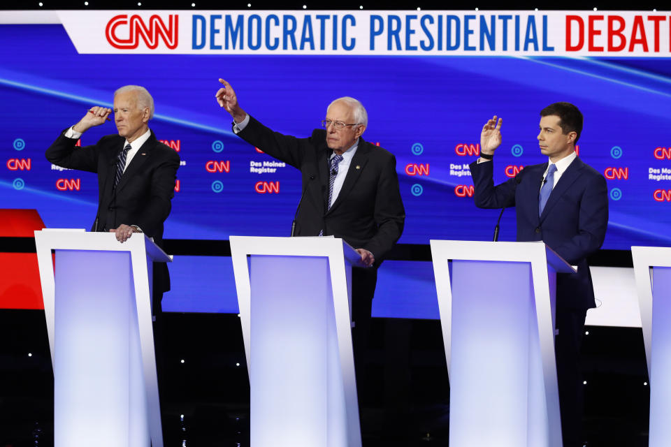 From left, Democratic presidential candidate former Vice President Joe Biden, Sen. Bernie Sanders, I-Vt.,and former South Bend Mayor Pete Buttigieg look to answer a question Tuesday, Jan. 14, 2020, during a Democratic presidential primary debate hosted by CNN and the Des Moines Register in Des Moines, Iowa. (AP Photo/Patrick Semansky)