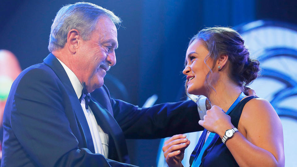 Pictured here, tennis great John Newcombe presents Ash Barty with a medal bearing his own name.