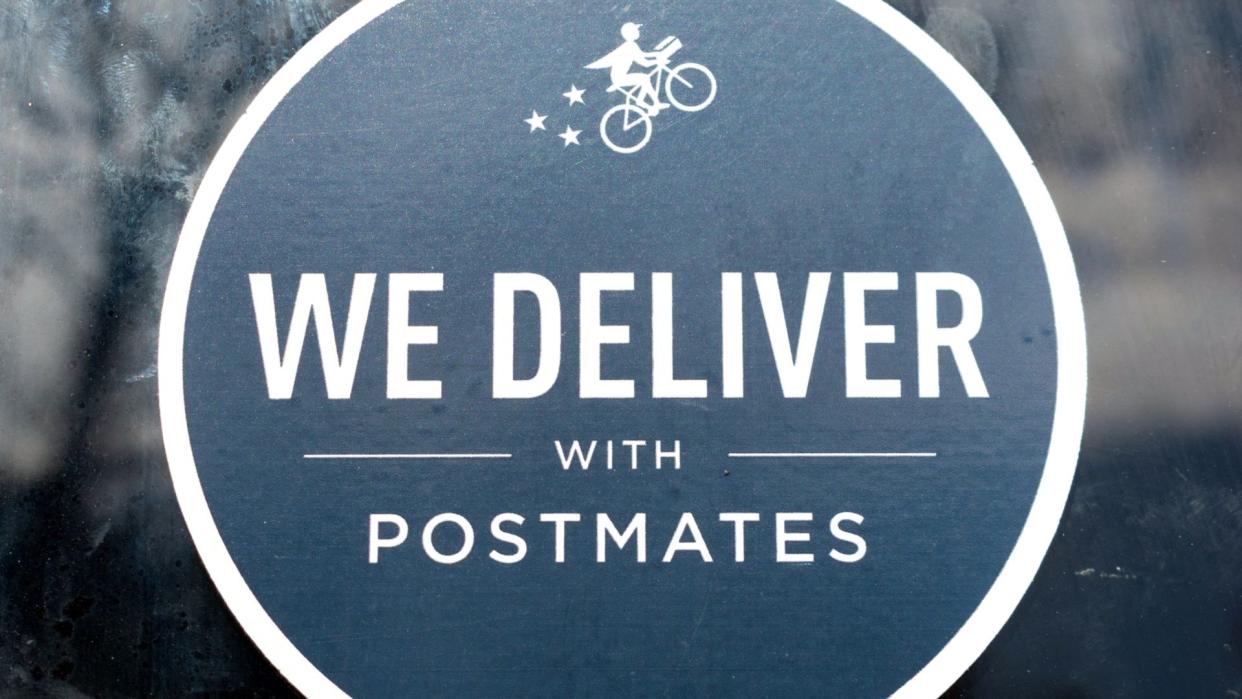 Close up. Postmates black sticker decal advertising delivery service available through Postmates goods delivery service - San Jose, California, USA - 2020