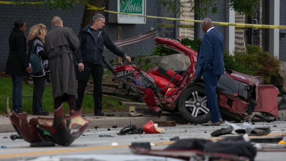 Investigators examine one half of a destroyed vehicle after an early morning crash that killed two people. The Special Investigations Unit says the driver was fleeing police. 