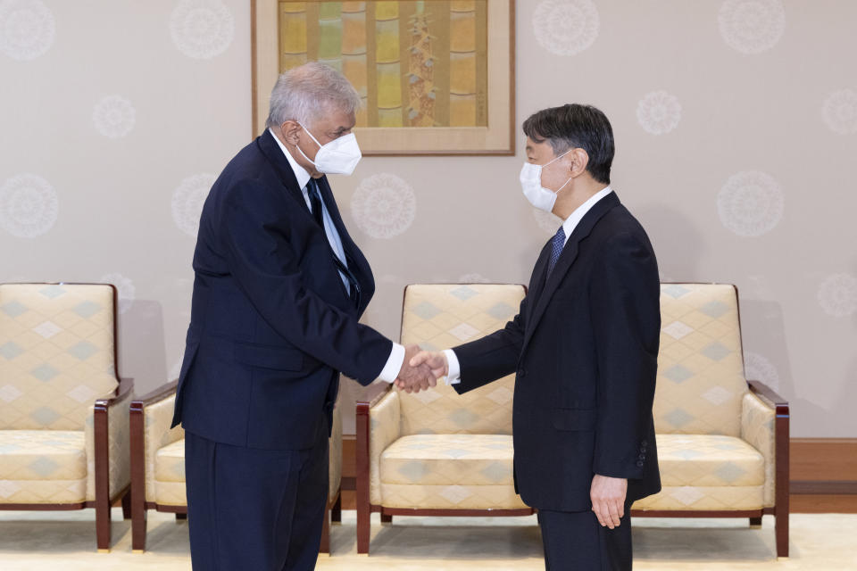 This handout photo taken and provided by the Imperial Household Agency of Japan shows Sri Lanka's President Ranil Wickremesinghe, left, shakes hands with Japan's Emperor Naruhito during their meeting at the Imperial Palace in Tokyo on Wednesday, Sept. 28, 2022. (The Imperial Household Agency of Japan via AP)