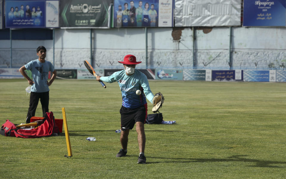 FILE - In this June 10, 2020, file photo, Javed Noori, a member of the Afghan cricket national team wears a protective face mask to help curb the spread of the coronavirus practice during his team's first training camp after the coronavirus pandemic hit the country, at the Kabul national cricket stadium in Kabul, Afghanistan. The pandemic-affected T20 World Cup will finally kick off in Oman and the United Arab Emirates on Sunday, Oct. 17, 2021, with no clear cut favorites this time around. (AP Photo/Rahmat Gul, File)