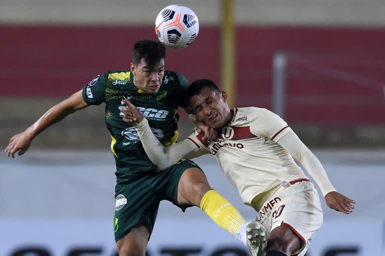 Fernando Meza, de Defensa y Justicia, pugna por la pelota con Alex Valera, de Universitario de Deportes (Perú) durante el partido entre ambos equipos por la Copa Libertadores; el Halcón se jugará la clasificación a octavos de final en la última fecha, cuando reciba a Independiente del Valle, de Ecuador.