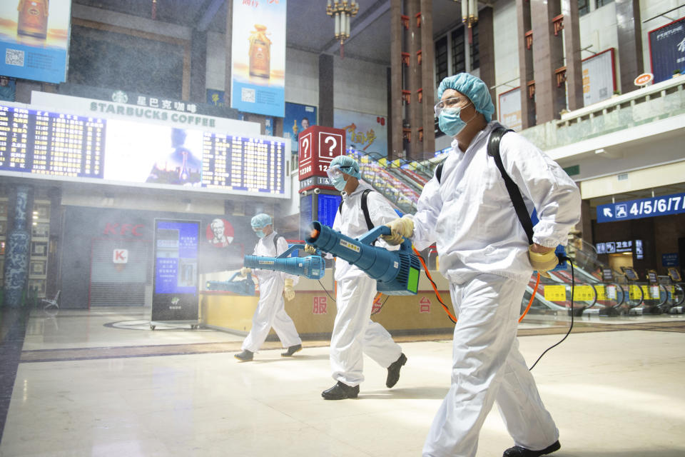 In this June 18, 2020, photo released by China's Xinhua News Agency, workers spray disinfectant in the central hall of the Beijing Railway Station in Beijing. New confirmed cases of coronavirus remained stable in China's capital on Friday after a public health official declared Beijing's latest outbreak under control. (Chen Zhonghao/Xinhua via AP)