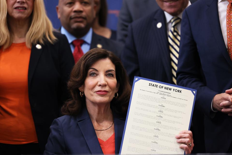 Gov. Kathy Hochul holds up signed legislation as she is surrounded by lawmakers during a bill signing ceremony at the Northeast Bronx YMCA on June 06, 2022 in New York City. Gov. Hochul signed a series of gun reform bills, that will strengthen already strict gun laws in the state.