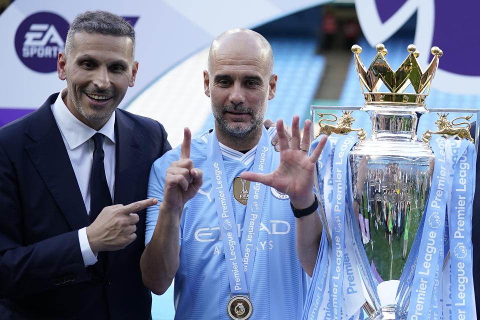Manchester City's head coach Pep Guardiola, right, and Manchester City chairman Khaldoon Al Mubarak celebrate with the Premier League trophy after the English Premier League soccer match between Manchester City and West Ham United at the Etihad Stadium in Manchester, England, Sunday, May 19, 2024. Manchester City clinched the English Premier League on Sunday after beating West Ham in their last match of the season. (AP Photo/Dave Thompson)