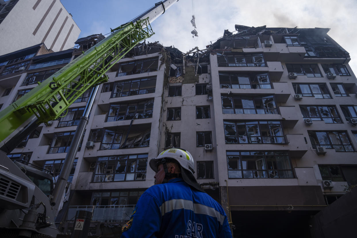 Firefighters work at the scene at a residential building following explosions, in Kyiv, Ukraine, Sunday, June 26, 2022. Several explosions rocked the west of the Ukrainian capital in the early hours of Sunday morning, with at least two residential buildings struck, according to Kyiv mayor Vitali Klitschko. (AP Photo/Nariman El-Mofty)