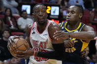 Miami Heat center Bam Adebayo, left, drives to the basket against Indiana Pacers guard Aaron Nesmith during the second half of an NBA basketball game, Wednesday, Feb. 8, 2023, in Miami. (AP Photo/Wilfredo Lee)