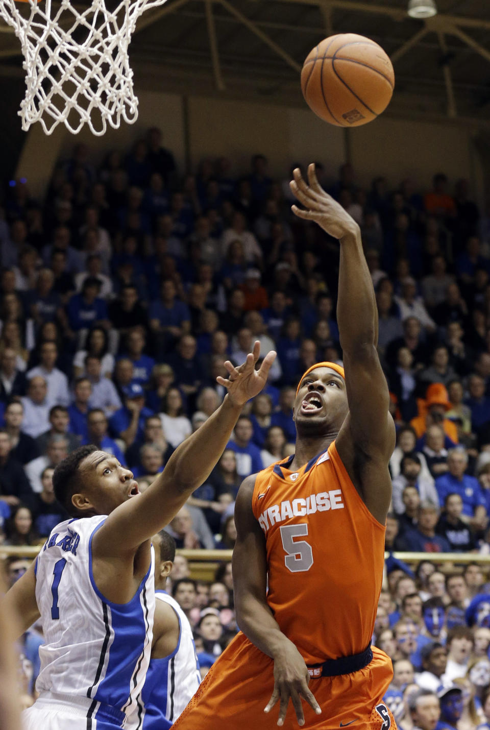 Duke's Jabari Parker (1) defends against Syracuse's C.J. Fair (5) during the first half of an NCAA college basketball game in Durham, N.C., Saturday, Feb. 22, 2014. (AP Photo/Gerry Broome)