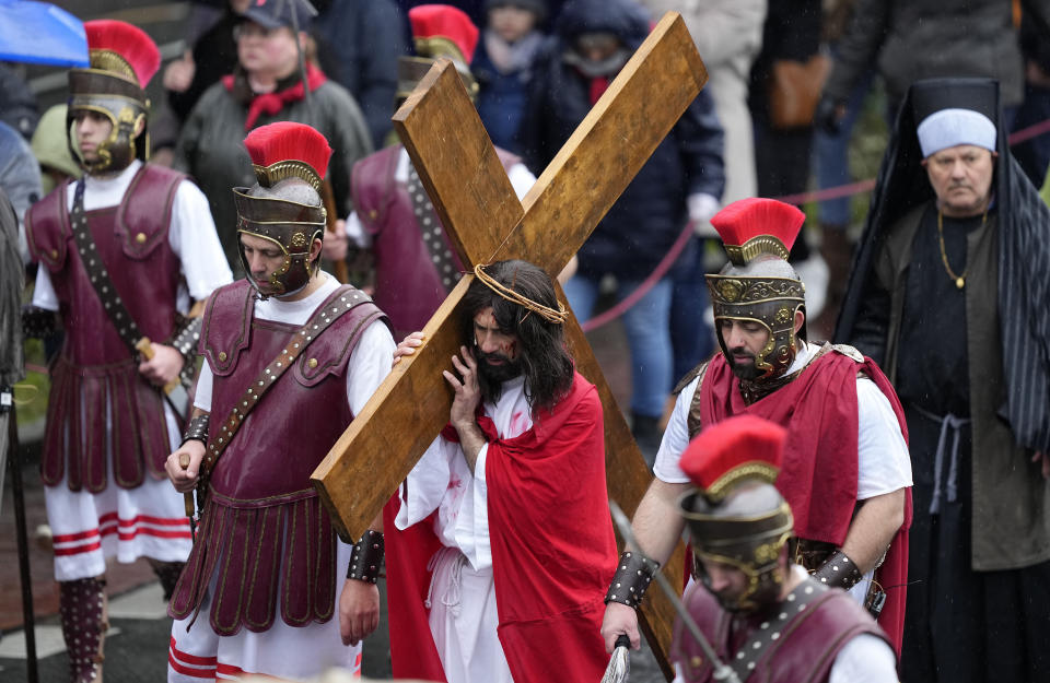 An actor portraying the part of Jesus Christ, carries the cross during the Good Friday procession in the city center of Wuppertal, Germany, Friday, April 7, 2023. Christians around the world are commemorating Good Friday, marking the crucifixion of Jesus Christ. (AP Photo/Martin Meissner)