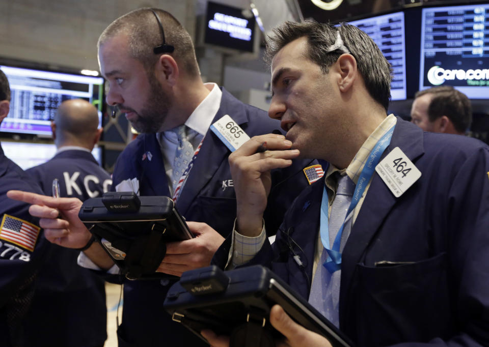 Traders Kevin Lodewick, left, and Gregory Rowe work on the floor of the New York Stock Exchange, Wednesday, Feb. 26, 2014. The stock market is little changed as investors pick over more earnings reports from retailers and other U.S. companies. (AP Photo/Richard Drew)