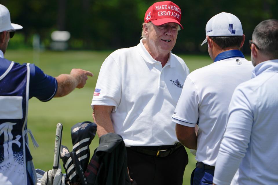 Former president Donald Trump talks with pro golfer Patrick Reed on the driving range before the second round of the LIV Golf event in May at Trump National Golf Club in Virginia.